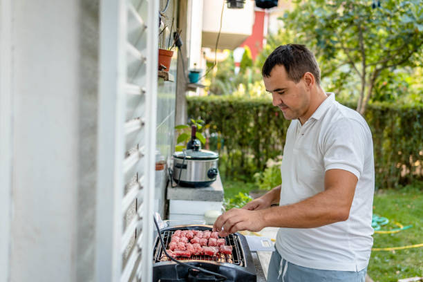 istock Man cooking meat on bbq 1341161315