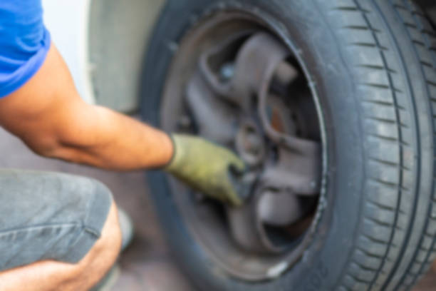 istock Hand of a worker changing car tire, blurred 1341165288