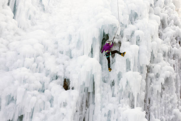 istock Ice climber at a frozen waterfall 1341170322