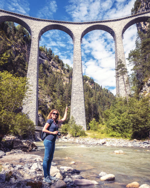 young female tourist visits landwasser viaduct in switzerland - travel vertical tourist switzerland imagens e fotografias de stock