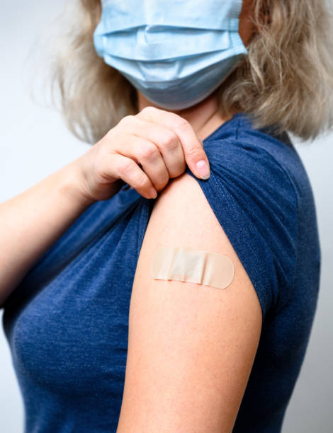 istock Vaccinated young woman showing arm with plaster 1341171352