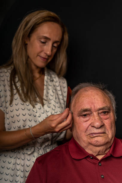 retrato de una hija peinando a su padre. - senior adult aging process old backdrop fotografías e imágenes de stock