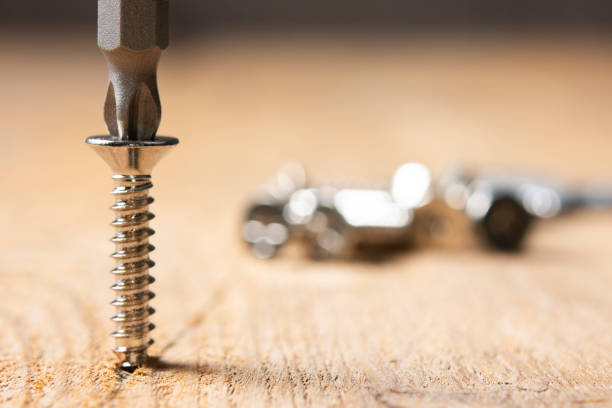 Screws screwed into wooden plank stock photo. Screws close up on wooden table. Screws screwed into wooden plank stock photo. Screws close up on wooden table. cordless phone stock pictures, royalty-free photos & images