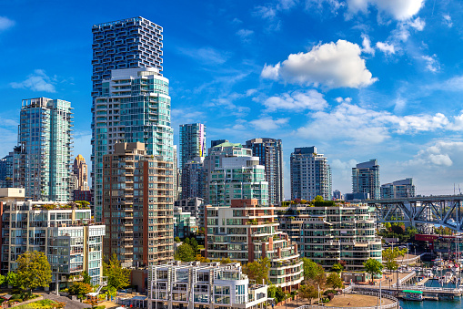 Cars and bus drive on Cambie Street in downtown Vancouver BC Canada on a sunny day.