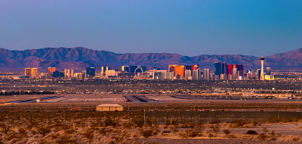 Panorama of the Las Vegas Skyline (featuring the Las Vegas Strip), with the Spring Mountain Range in the background, and an airport and desert land in the foreground.  Image can also be used as a dusk photo.