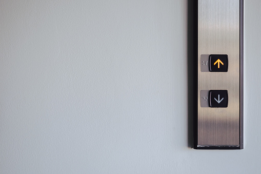 Botón de arriba y abajo frente al ascensor para la dirección, luz roja hacia arriba con espacio de copia photo
