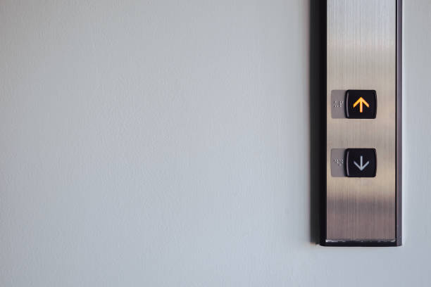 botão para cima e para baixo na frente do elevador para direção, luz vermelha para cima com espaço de cópia - elevador - fotografias e filmes do acervo