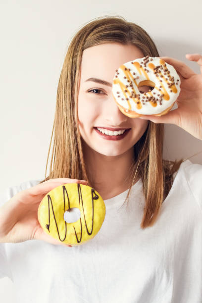 istock Beautiful girl holding donuts and having fun 1341178554