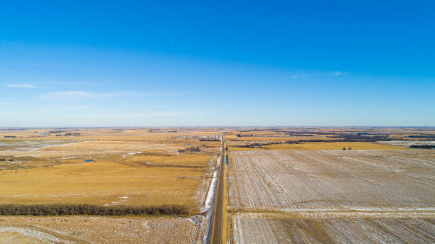 the scenic panoramic aerial view of the small highway between the harvested fields in the country farmland. the pony express historic route - us route 136 in nebraska nearby the border with kansas, central usa. - pony express imagens e fotografias de stock