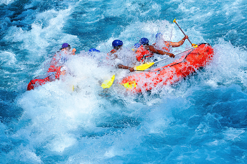 a group of male and female people doing for rafting on a clean river with a relatively calm water in summer day for having fun leisure time activity sports concepts with copy space