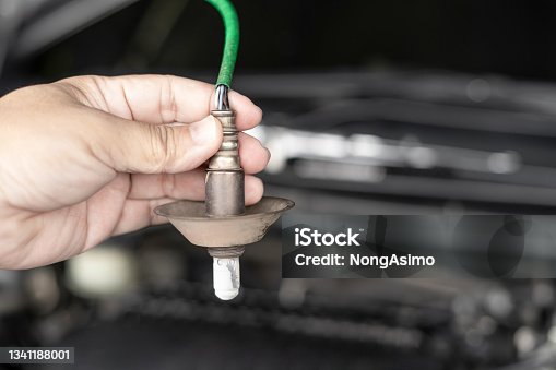 istock Close up hand car mechanic hold oxygen sensor of exhaust system of gasoline engine checking for faults in the exhaust system in the maintenance of the vehicle that has been used for a long time 1341188001