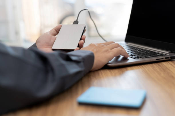 External backup disk in hard a man connected to laptop computer safety personal data copy Prevent data corruption in the computer system
