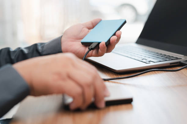 istock External backup disk in hard a man connected to laptop computer safety personal data copy Prevent data corruption in the computer system 1341188050