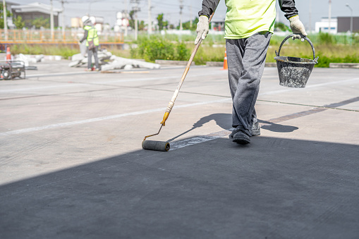 Worker mark thermoplastic paint primer on the floor use for Traffic marking machine working in process