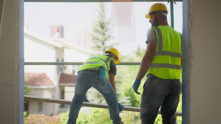 Construction workers applying plaster on building facade