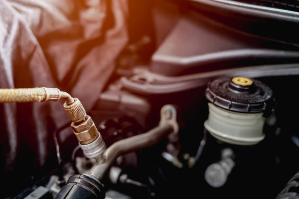 old car spark plug in a hand of technician remove and change in engine room blur background service concept - vela de ignição imagens e fotografias de stock