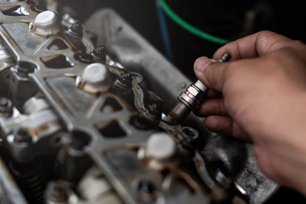 alte autozündkerze in einer hand des technikers entfernen und ändern im maschinenraum unschärfe hintergrund servicekonzept - mechanic technician working human hand stock-fotos und bilder