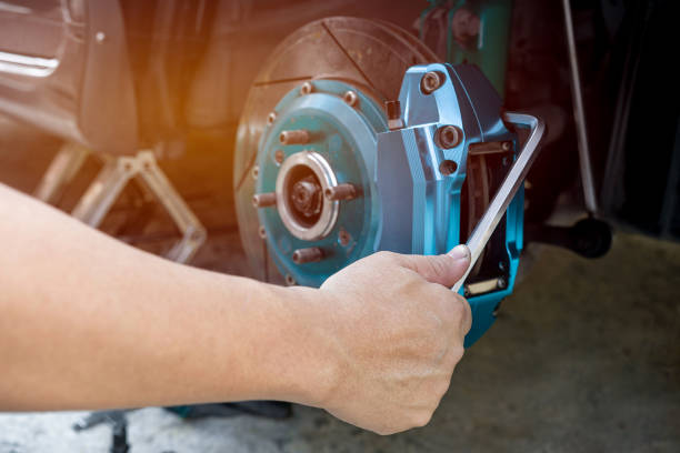 inicio concepto de servicio básico : un hombre usa la llave l quitar la pinza de freno de perno del automóvil en el concepto de automóvil de mantenimiento - caliper fotografías e imágenes de stock