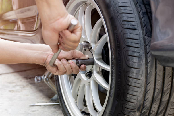 home service car konzept: ein mann repariert aktion schloss bolzen des autorads zur überprüfung des antriebssystems des autos grundlegende wartung, die von ihnen selbst durchgeführt werden kann - wheel lug stock-fotos und bilder