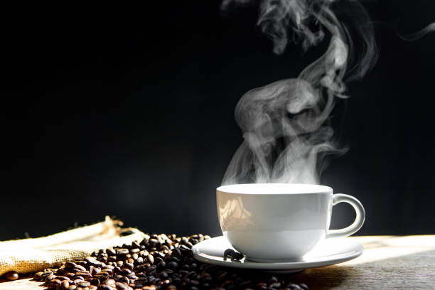 istock White Coffee mug and coffee bean on the wood table in dark background 1341193730