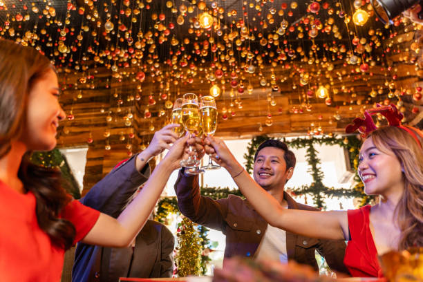 美しいアジアの友人の女性と男性のパーティーを祝う。幸せな友人クリスマスイブは、食べ物とシャンパンでディナーパーティーを祝います。人々は楽しい瞬間と一緒に話し、飲みます。 - party business toast champagne ストックフォトと画像