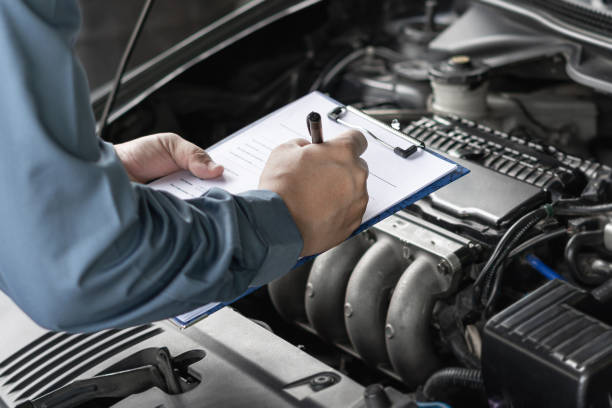 istock Close up hand car service staff check engine malfunctions and mistake check list in engine room : Car service concept 1341196588