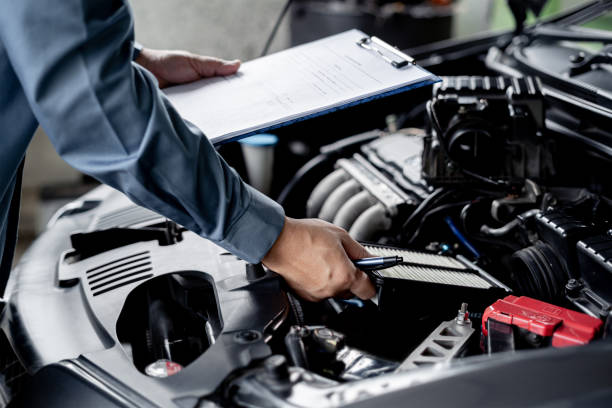 istock Technician hold and check the engine air filter in engine room and check list service work in the garage  : Car service concept 1341196597