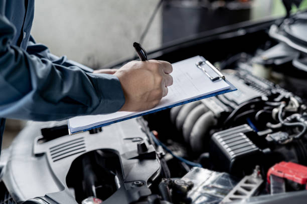 istock Close up hand car service staff check engine malfunctions and mistake check list in engine room : Car service concept 1341196598