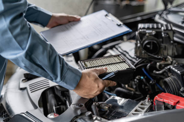 istock Technician hold and check the engine air filter in engine room and check list service work in the garage  : Car service concept 1341196600
