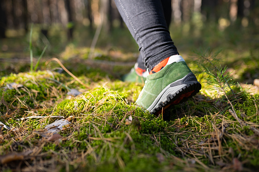Person walking in the woods. Speed-hiking shoes closeup.