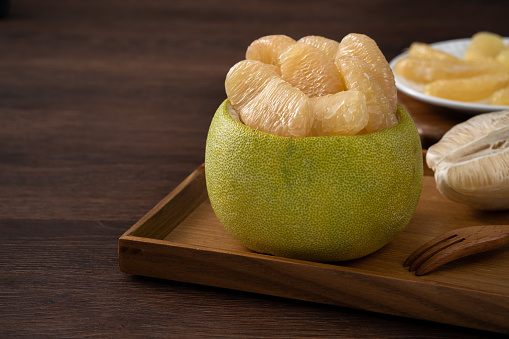 Close up of fresh peeled pomelo on wooden table background for Mid-Autumn Festival fruit.