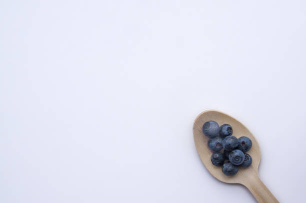 istock Isolated recycled spoon and juicy, fresh blueberries on white table 1341216576