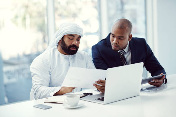 istock Shot of two businessmen using a digital tablet and laptop while having a discussion in a modern office 1341217583