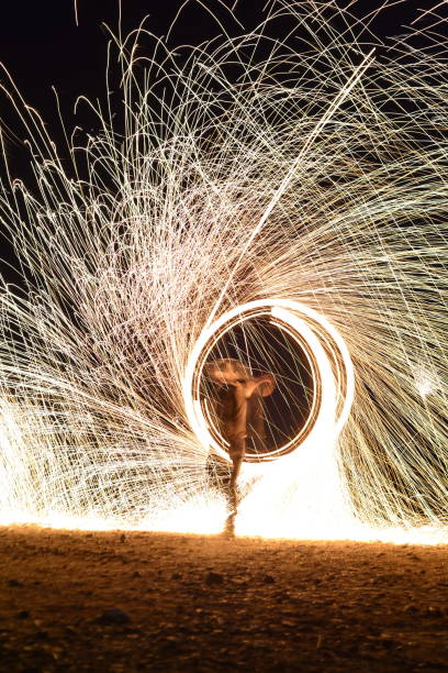 istock Iron wool circle drawing light fireworks. Burning Steel Wool spinning, Trajectories of burning sparks at night. Movement light effect, steel wool fire hoop. long exposure light painting, Pyrotechnic 1341219433