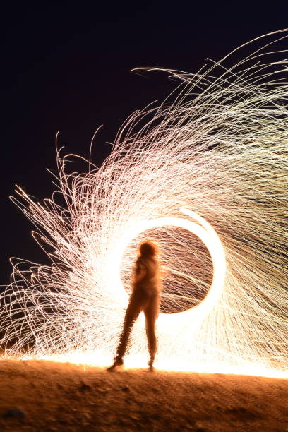 istock Iron wool circle drawing light fireworks. Burning Steel Wool spinning, Trajectories of burning sparks at night. Movement light effect, steel wool fire hoop. long exposure light painting, Pyrotechnic 1341220279