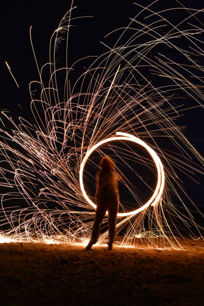 Iron wool circle drawing light fireworks. Burning Steel Wool spinning, Trajectories of burning sparks at night. Movement light effect, steel wool fire hoop. long exposure light painting, Pyrotechnic círculo de lana de hierro dibujando fuegos artificiales ligeros. quema de lana de acero hilado, trayectorias de chispas ardientes por la noche. efecto de luz de movimiento, aro de fuego de lana de acero. pintura de luz de larga exposición, pirotecnia