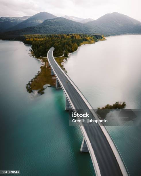 Woman Crossing The Bridge Over Lake On A Foggy Winter Day Stock Photo - Download Image Now