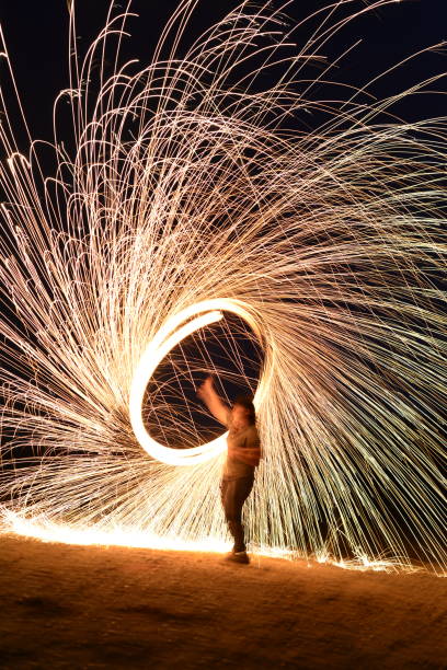 istock Iron wool circle drawing light fireworks. Burning Steel Wool spinning, Trajectories of burning sparks at night. Movement light effect, steel wool fire hoop. long exposure light painting, Pyrotechnic 1341221364