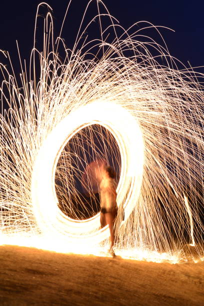 istock Iron wool circle drawing light fireworks. Burning Steel Wool spinning, Trajectories of burning sparks at night. Movement light effect, steel wool fire hoop. long exposure light painting, Pyrotechnic 1341221547
