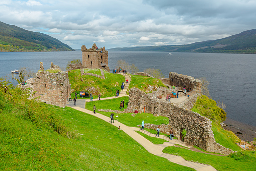 Loch Ness, Scotland, United Kingdom - May 24, 2015: aerial view of tourists visiting Urquhart Castle beside Loch Ness lake. Visited for the legend of the Loch Ness monster: Nessie.
