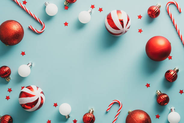 istock Vintage Christmas frame with red and white striped balls, candy canes, decorations on blue background. Flat lay, top view, copy space. 1341226993