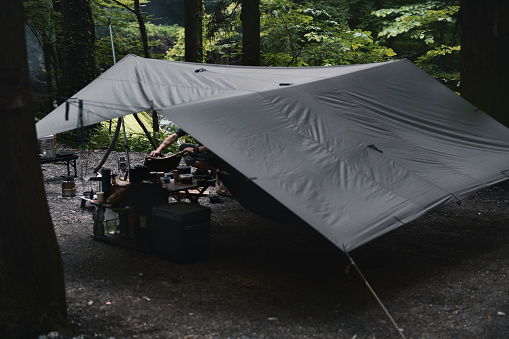 Tarp in the forest by a male camper