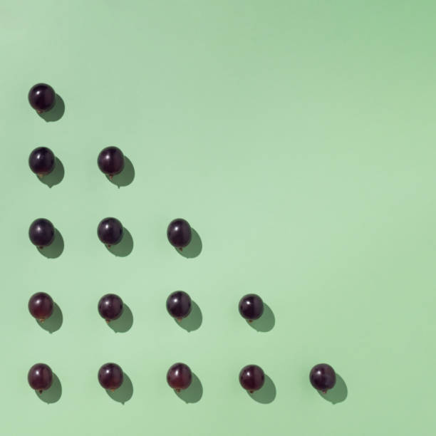 istock Grapes arranged in a triangle. Minimalist autumn compositions. 1341230511