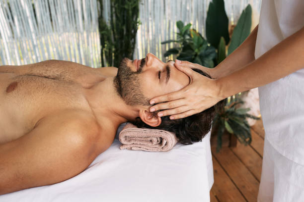 istock Relaxed man gets head massage at spa. Anti-stress head massage, side view 1341231007