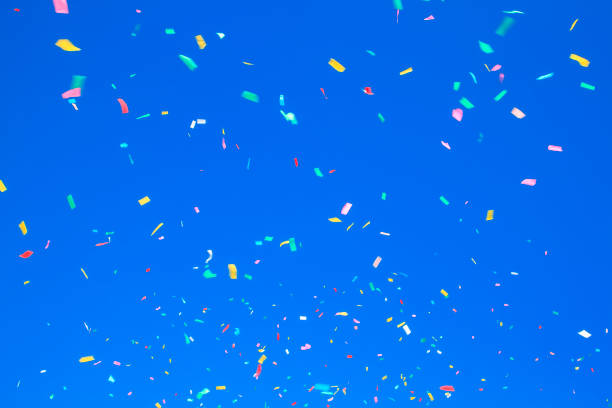 istock multicolored confetti on clear blue sky background. Concept of h 1341231870