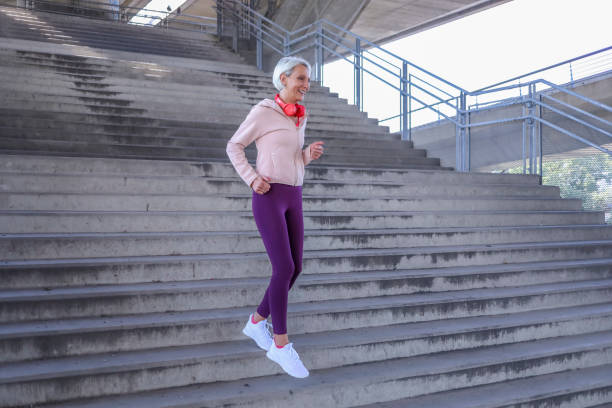 istock Senior athletic woman jogging upstairs 1341237887