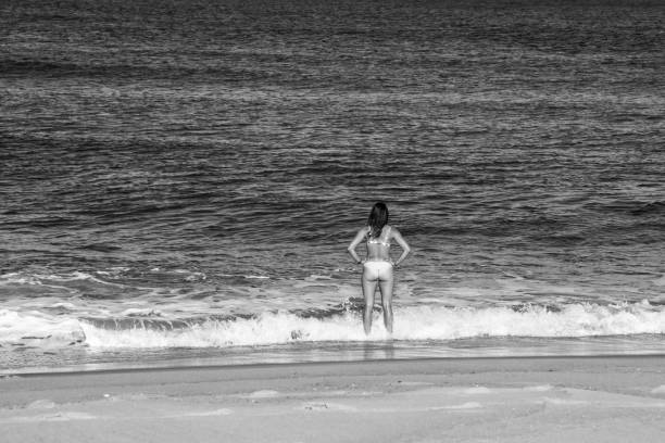 istock pretty young woman walking on sunny beach in bikini 1341240486