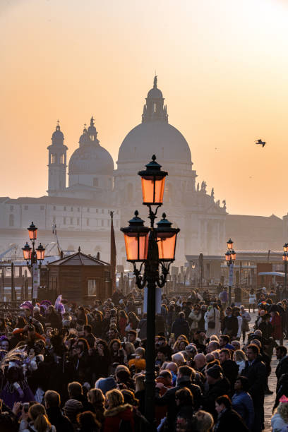 touristenmasse beim karneval auf dem markusplatz, im hintergrund die basilika santa maria della salute, venedig, italien, europa - scenics building exterior tourist resort orange stock-fotos und bilder