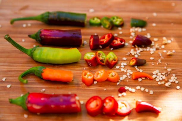 Close up image depicting an overhead angle of a pile of freshly chopped red and green chili peppers.