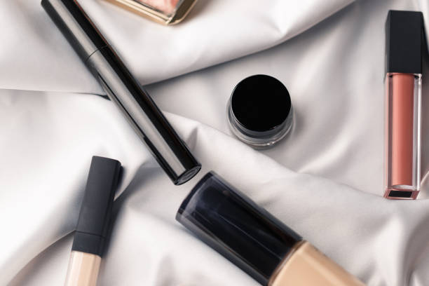 istock Set of professional elite decorative cosmetics for make-up on white silk cloth. Textile background. Copy space. Beauty and fashion concept. Cosmetic beauty products: lipstick, eye shadow, foundation 1341244679